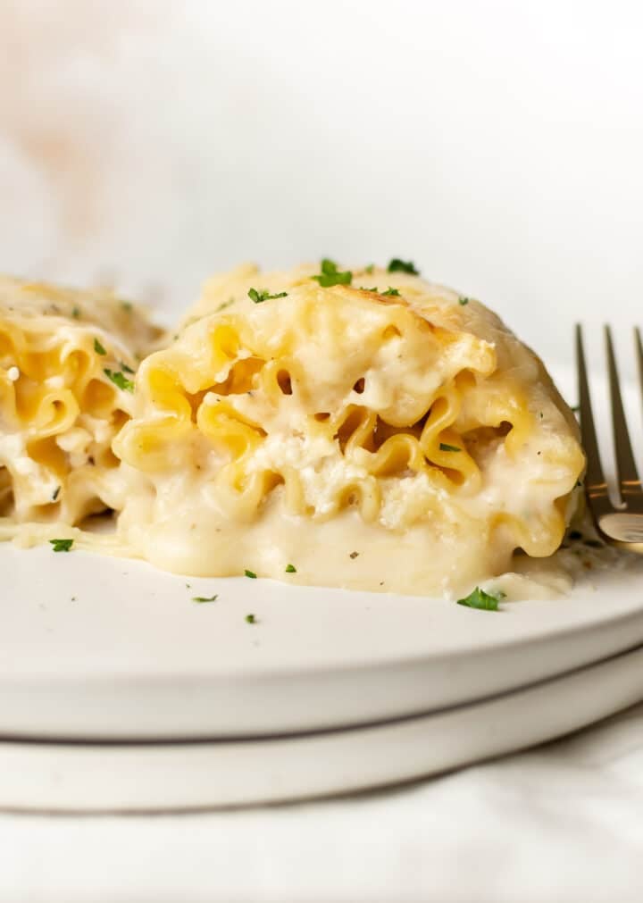 a plate with a chicken lasagna roll up and a fork