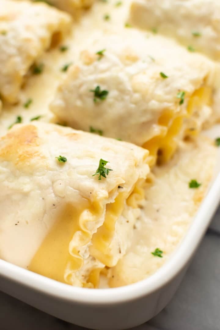 closeup of a baking dish with chicken lasagna roll ups