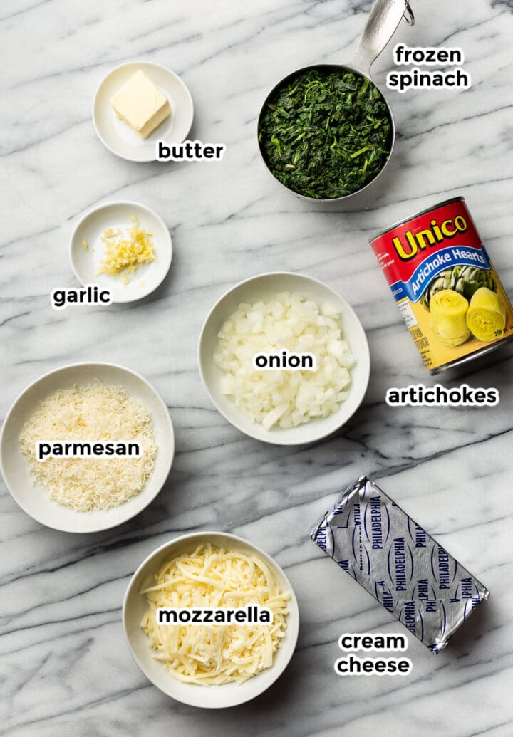 ingredients for spinach artichoke dip in prep bowls