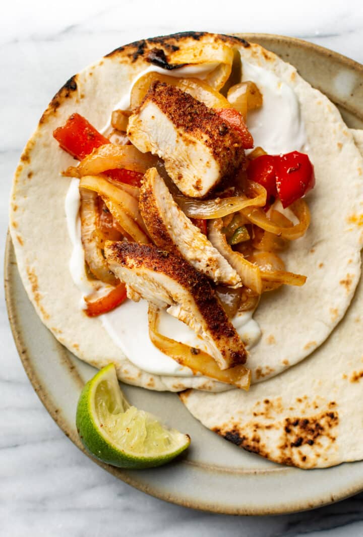 chicken fajitas on a plate with a lime wedge