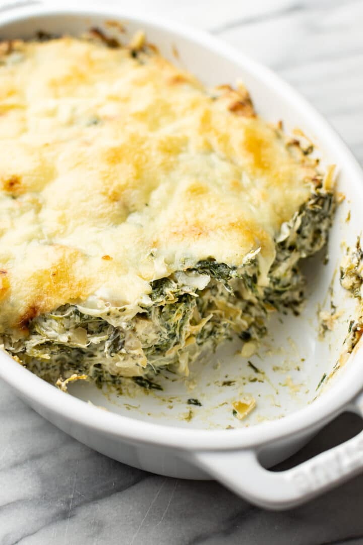 a baking dish with spinach artichoke dip