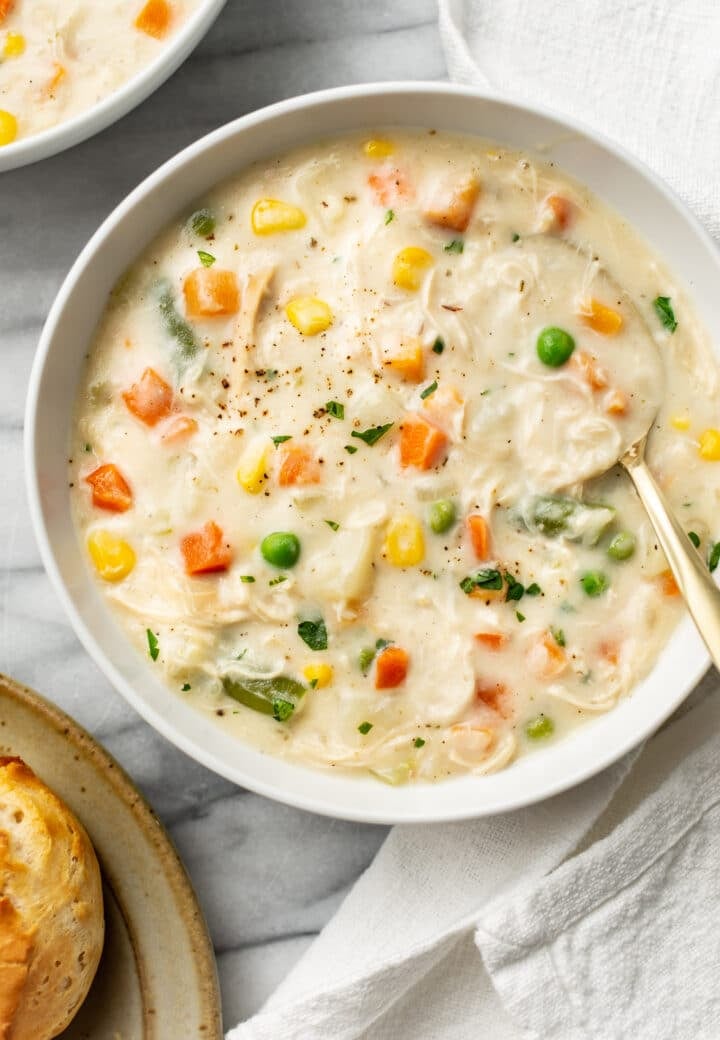 chicken pot pie soup in a bowl next to biscuits