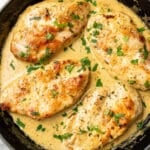 a skillet with four chicken cutlets in a creamy tarragon sauce