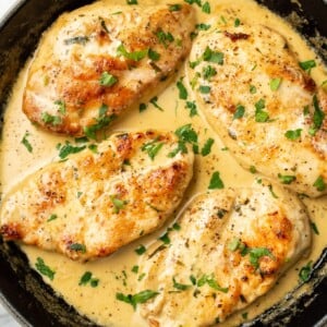 a skillet with four chicken cutlets in a creamy tarragon sauce