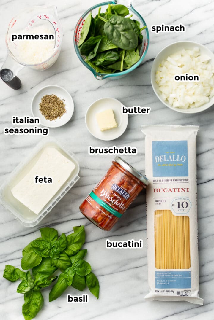ingredients for baked feta pasta on a marble counter