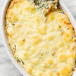 a baking dish with spinach artichoke dip