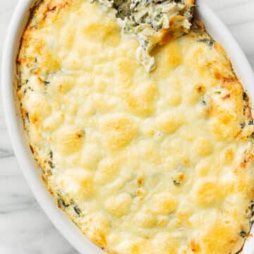a baking dish with spinach artichoke dip
