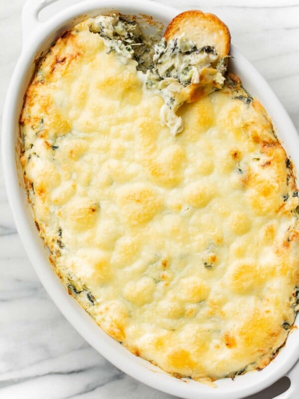 a baking dish with spinach artichoke dip