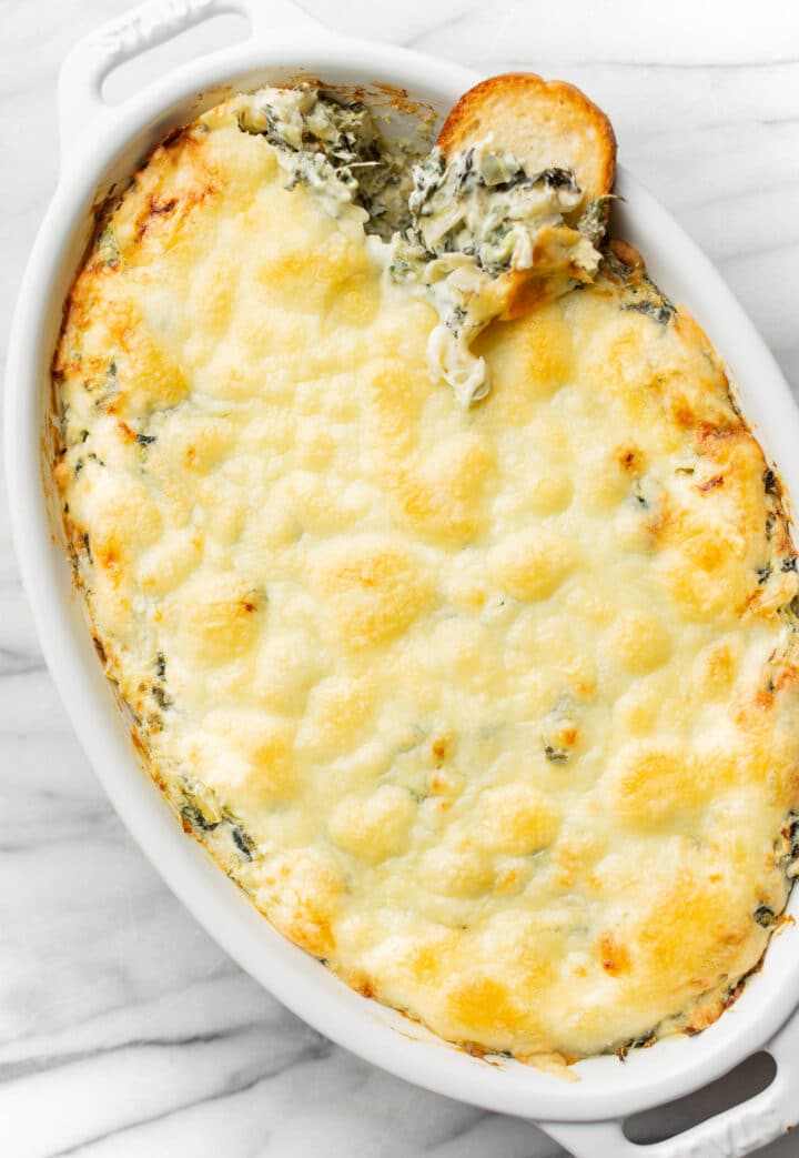 a baking dish with spinach artichoke dip