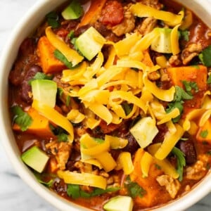 a bowl of sweet potato turkey chili with toppings