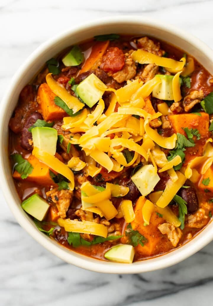 a bowl of sweet potato turkey chili with toppings