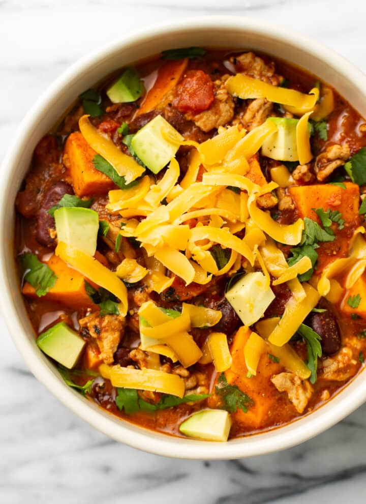 a bowl of sweet potato turkey chili with toppings
