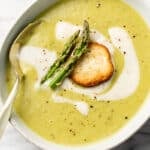 a bowl of asparagus soup with a spoon