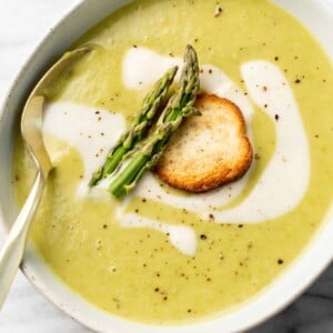 a bowl of asparagus soup with a spoon