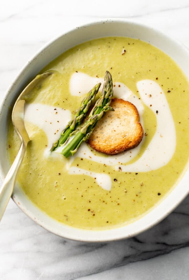 a bowl of asparagus soup with a spoon