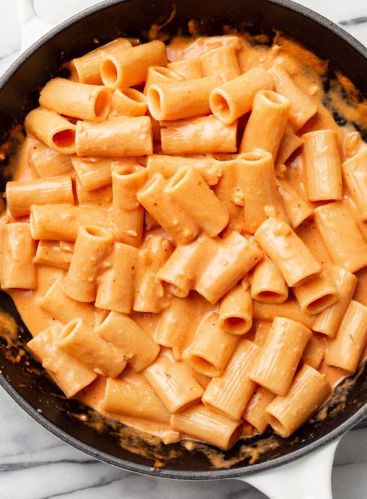 a cast iron skillet with pasta and a pink sauce