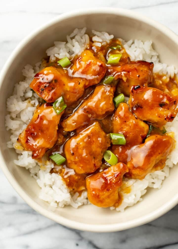 homemade orange chicken over rice in a bowl