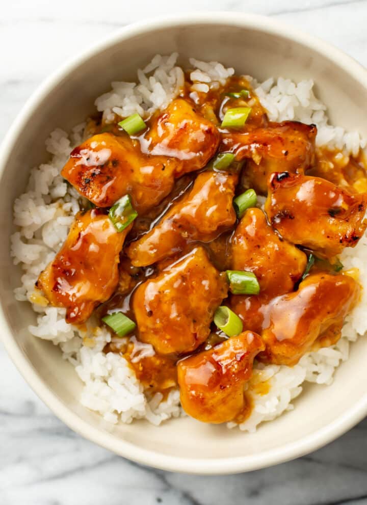 homemade orange chicken over rice in a bowl