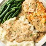 a plate with chicken in cream of mushroom sauce, green beans, and mashed potatoes