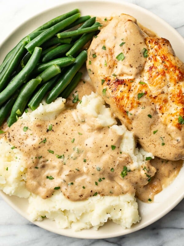 a plate with chicken in cream of mushroom sauce, green beans, and mashed potatoes