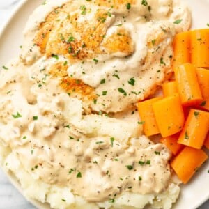 a plate with cream cheese chicken, carrots, and mashed potatoes