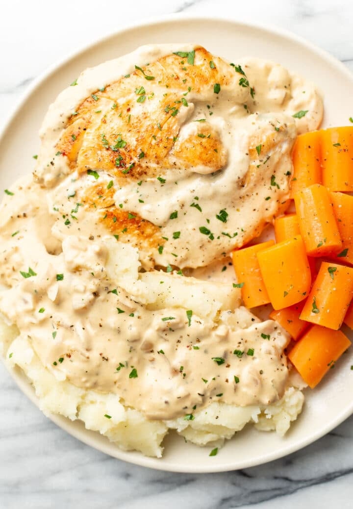 a plate with cream cheese chicken, carrots, and mashed potatoes