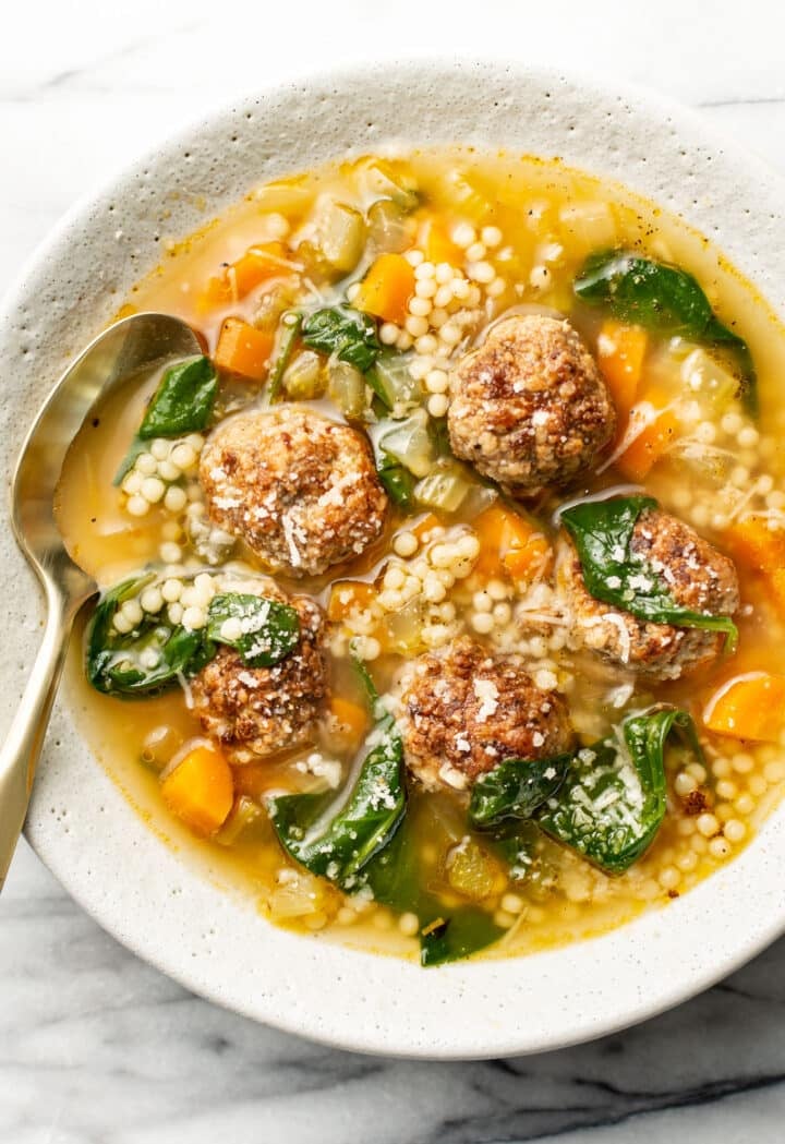 a bowl of italian wedding soup with a spoon