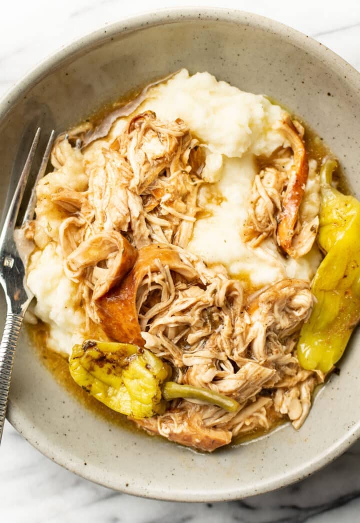 a bowl with Mississippi chicken over mashed potatoes