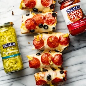 several slices of french bread pizza next to jars of ingredients