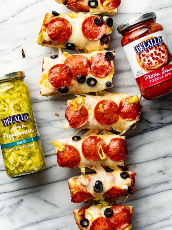 several slices of french bread pizza next to jars of ingredients