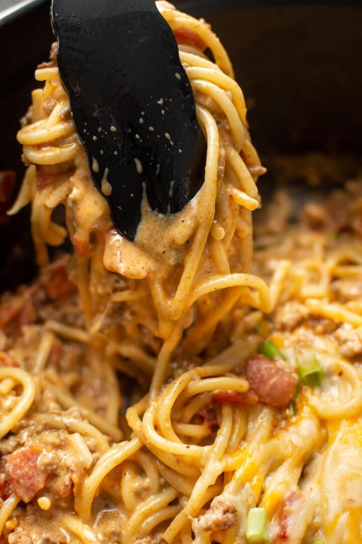 a pair of kitchen tongs serving taco spaghetti