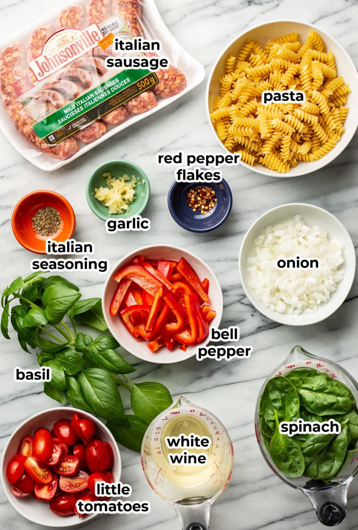 ingredients for sausage and vegetable pasta in prep bowls