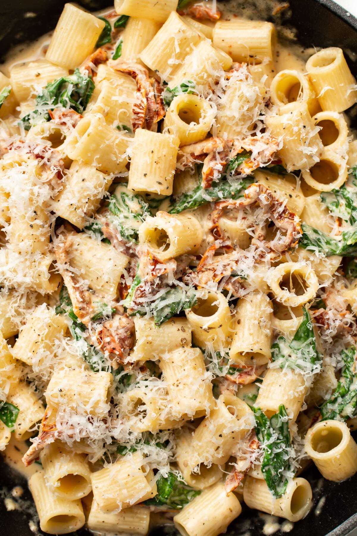 closeup of rigatoni in creamy sun-dried tomato sauce in a skillet