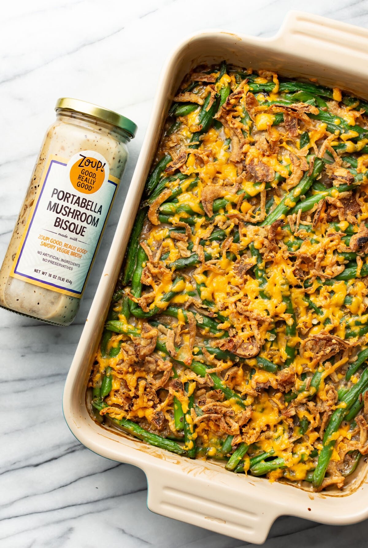 a baking tray with green bean casserole next to a jar of soup