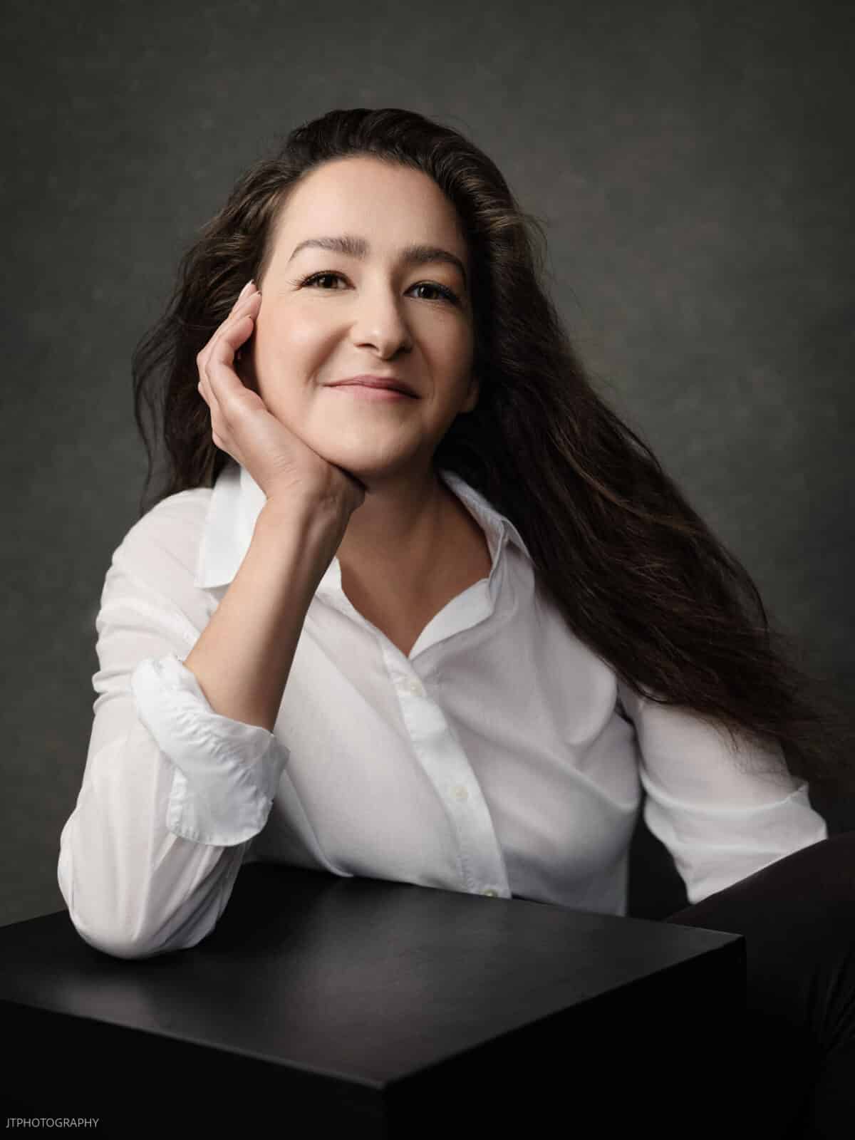 Headshot of Miranda Sayer of Salt & Lavender resting her face on her hand while leaning her elbow on a table