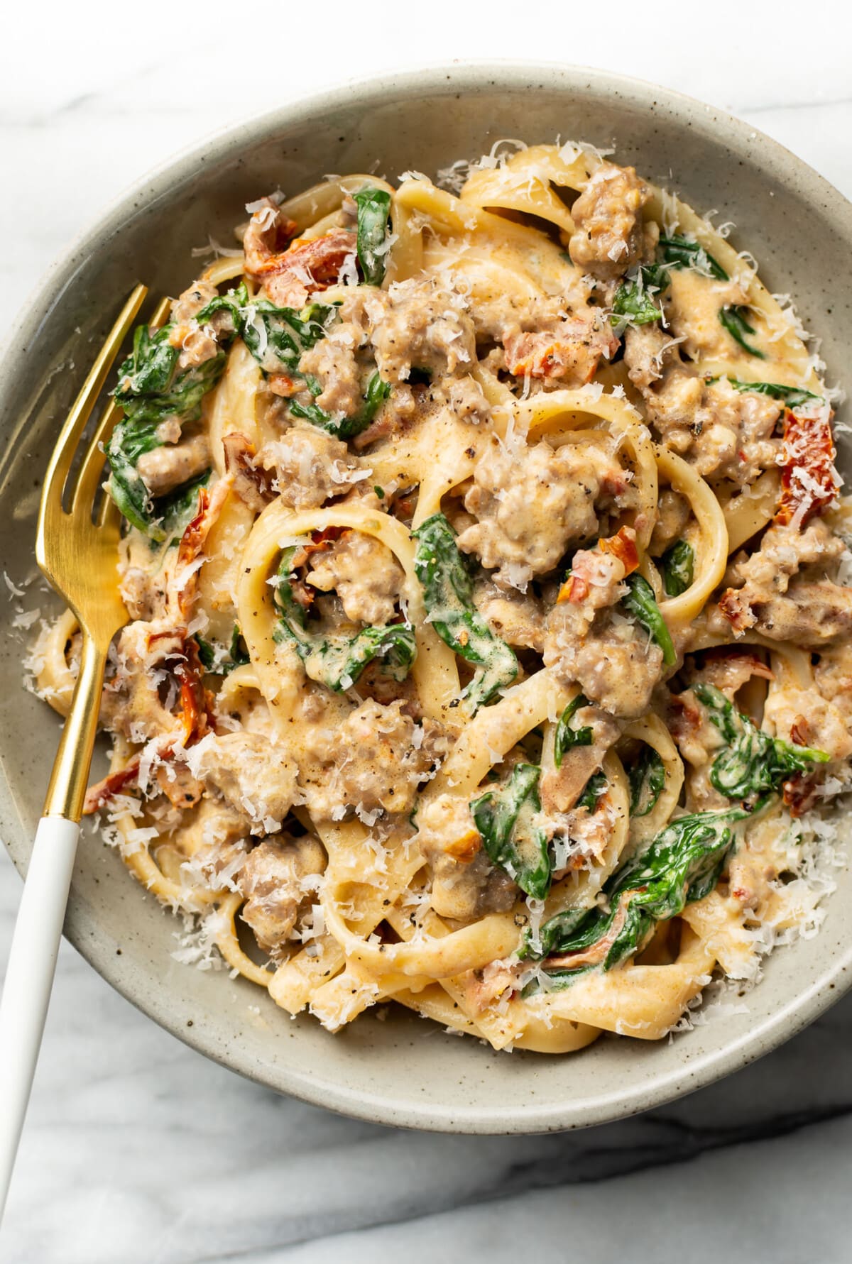 a bowl of Tuscan sausage pasta with a fork