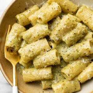 a bowl of pesto pasta with a fork