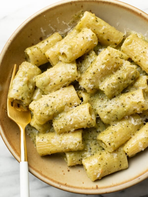 a bowl of pesto pasta with a fork