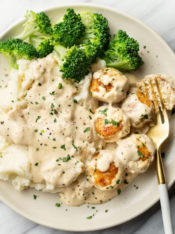 a plate with ranch chicken meatballs, mashed potatoes, broccoli, and a fork