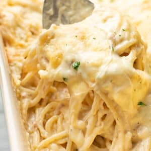 closeup of a casserole dish with ranch chicken spaghetti and a serving spoon