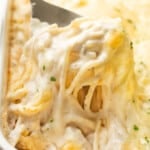 closeup of a baking dish with turkey tetrazzini and a serving spoon