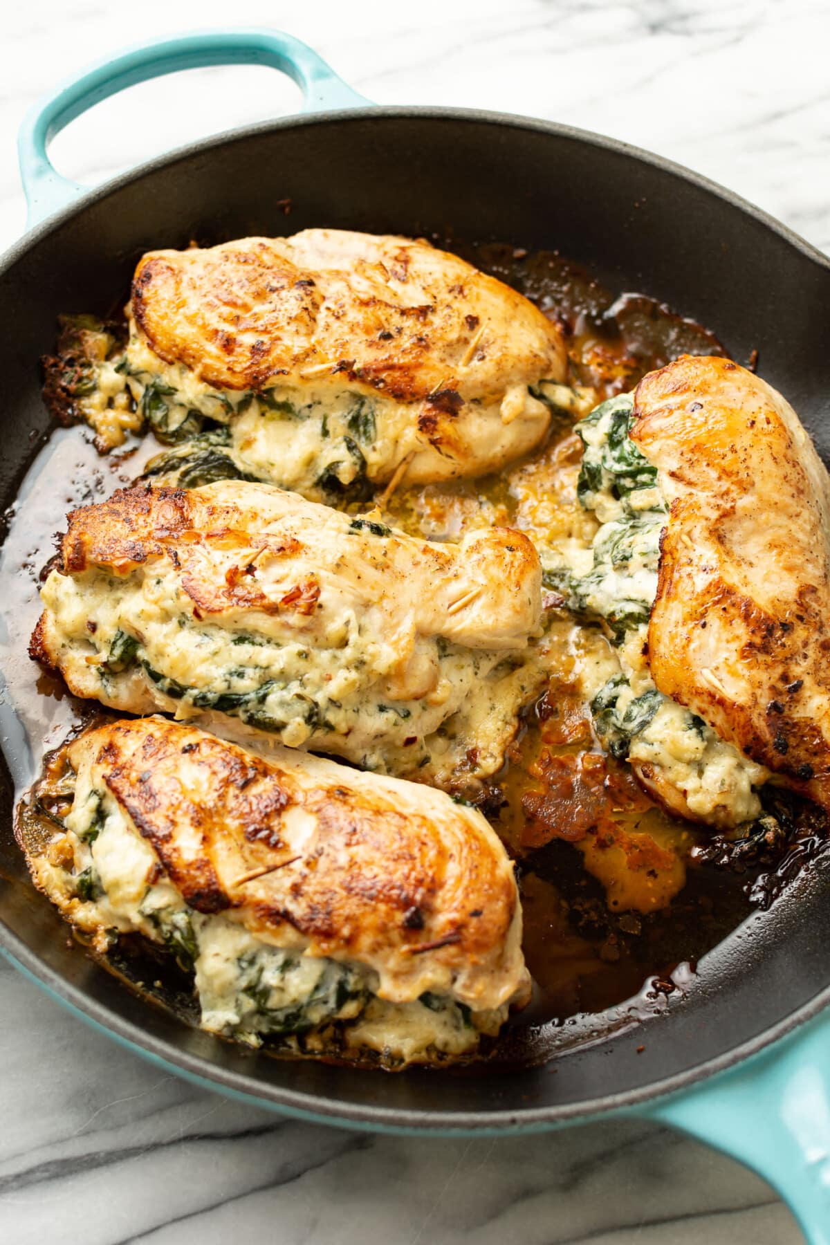 a skillet with four boursin stuffed chicken breasts
