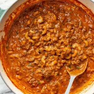 a large pot with chili mac and a serving spoon