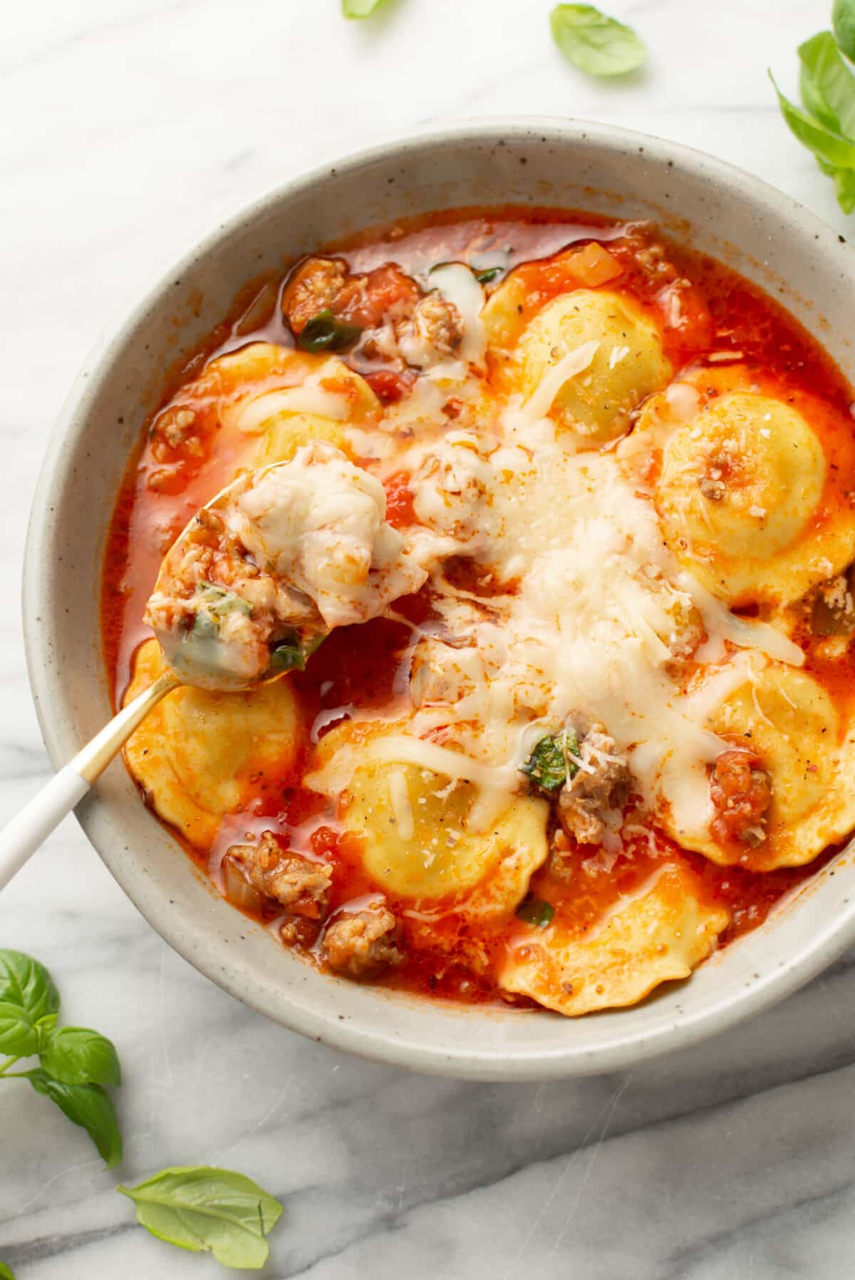 a bowl of ravioli soup with a spoon