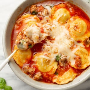 a bowl of ravioli soup with a spoon