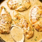 a skillet with creamy maple chicken and a serving spoon