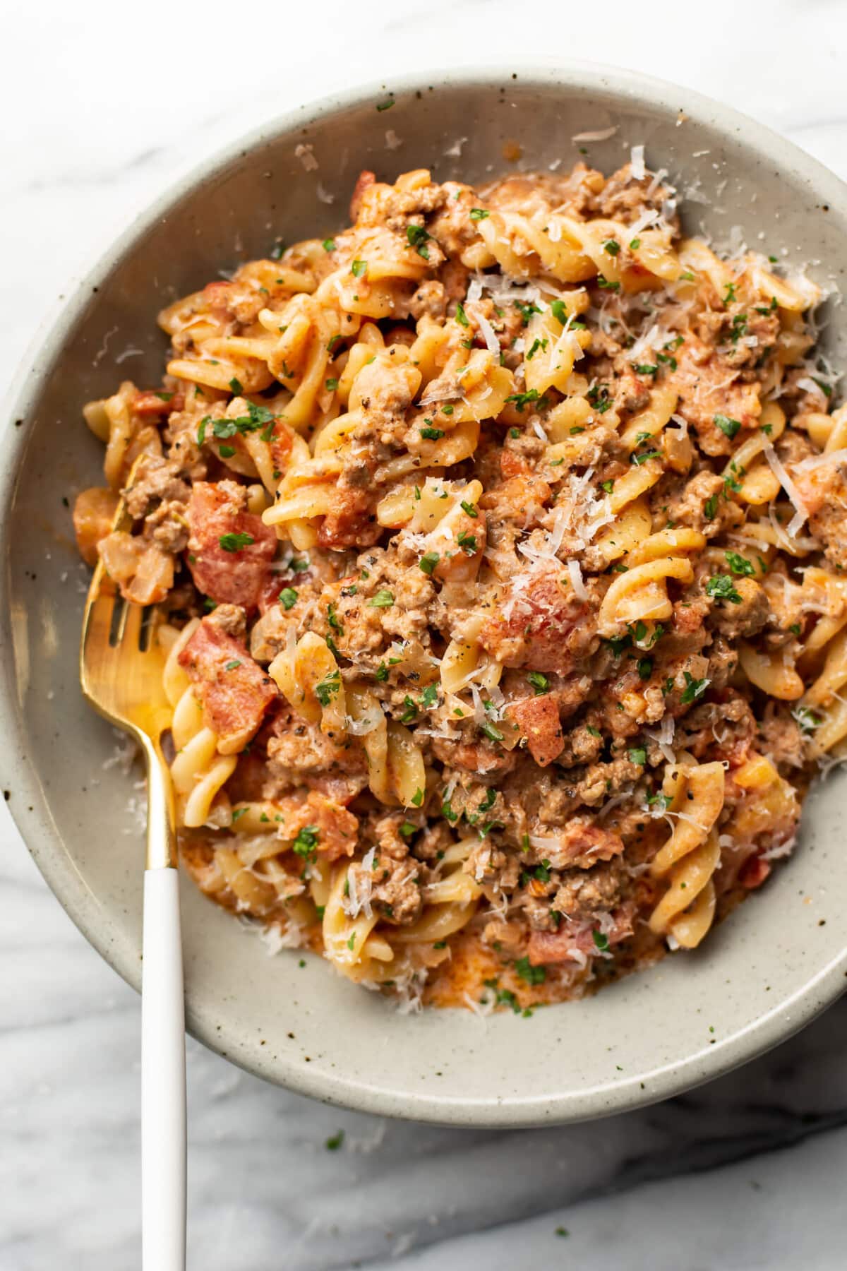 a bowl with creamy ground beef pasta and a fork