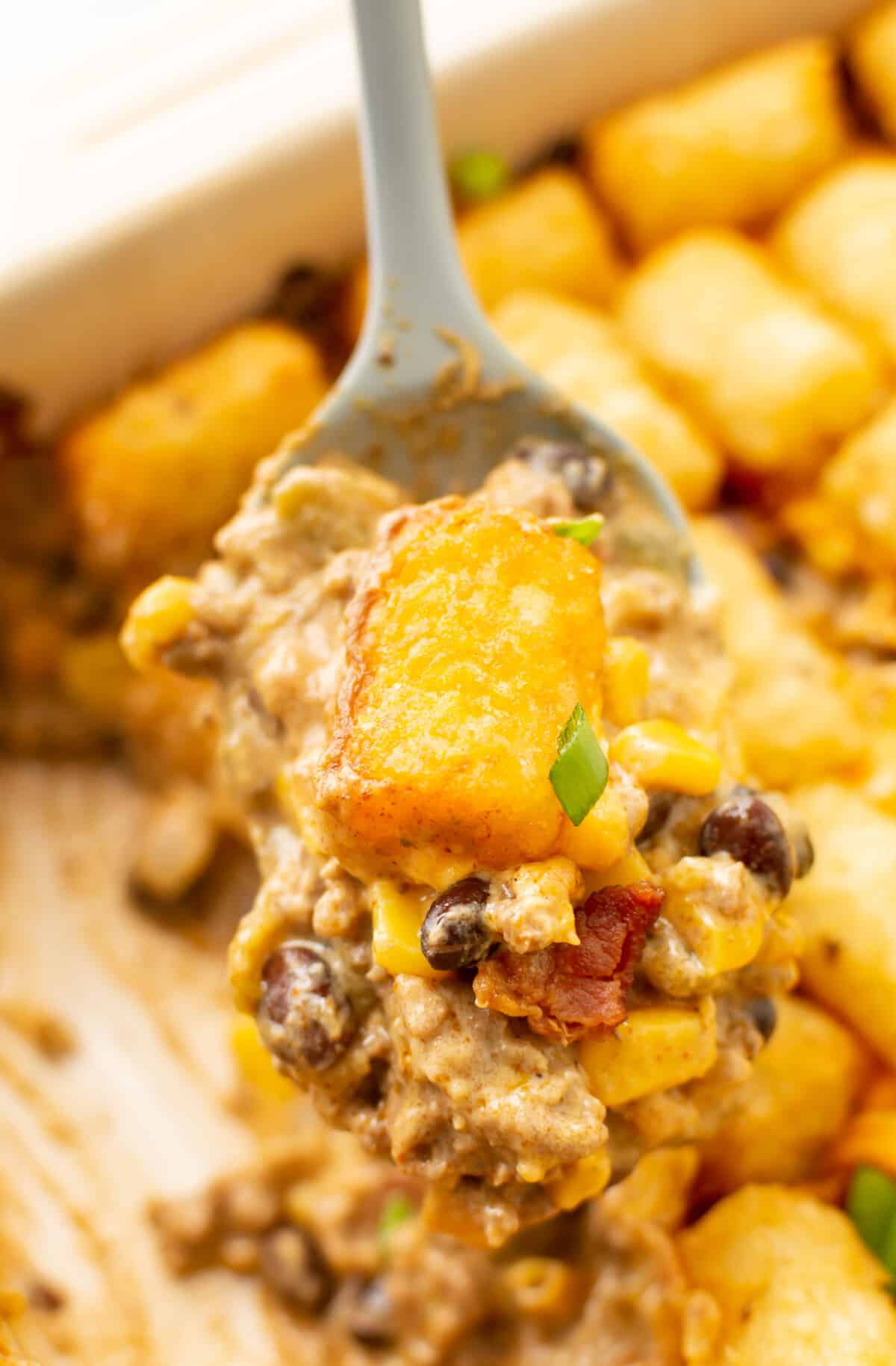 closeup of a spoonful of cowboy casserole over a baking dish
