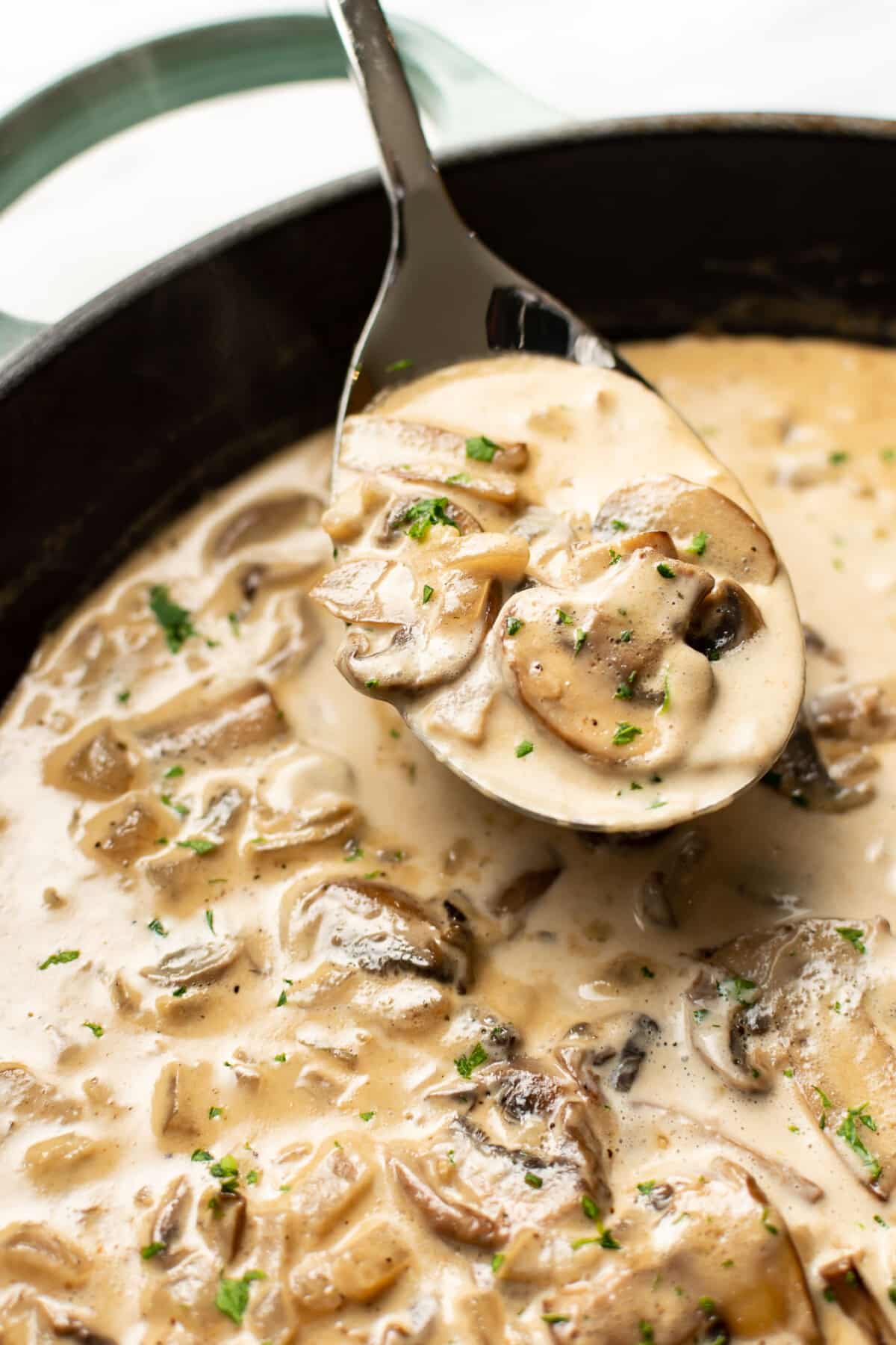 a skillet with marsala sauce and a serving spoon