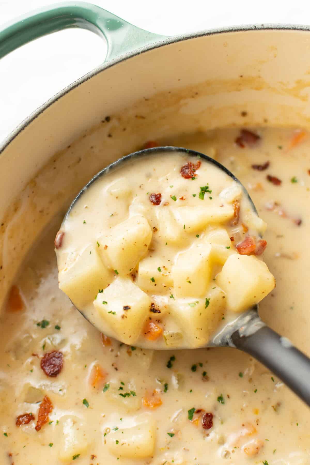 closeup of a pot with bacon potato soup and a ladle